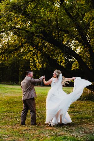 A playful sequence of wedding photos shows a couple in formalwear dancing and twirling in a sunlit outdoor garden setting.
