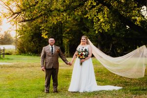 Autumn wedding sequence showing couple in brown suit and flowing white gown amid golden trees.