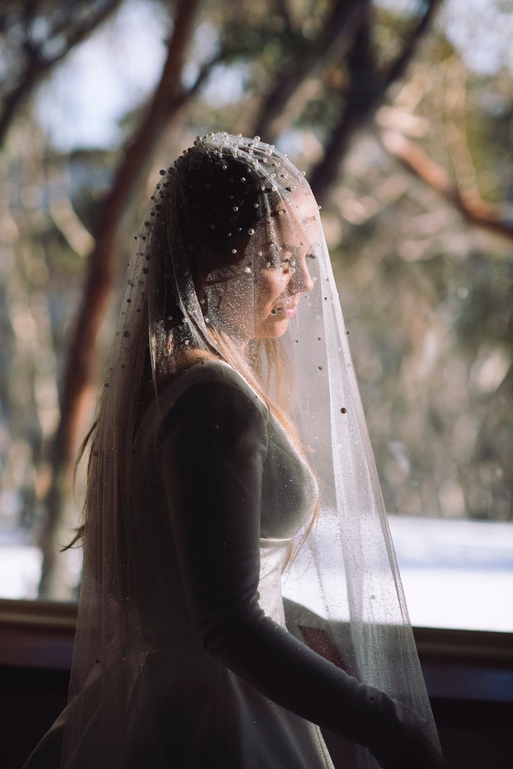 A series of silhouettes against a bright background show a bride with a veil in artistic motion shots.