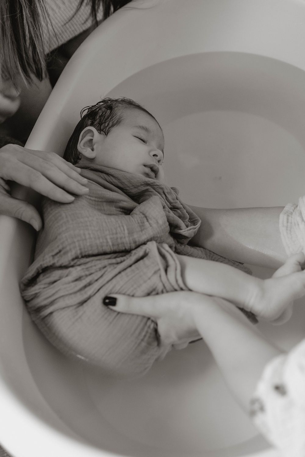 A black and white photo sequence shows a person bathing in a vintage clawfoot tub.