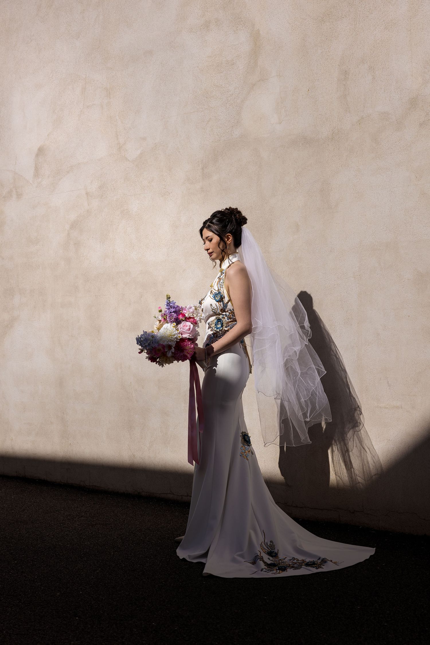 A portait of a Bride in her 'East meets Dress' wedding gown holding a brightly colored floral bouquet during wedding preparation in Albury.