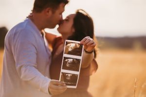 Maternity photo with Urso Photography, with expectant mother holding ultrasound photos, celebrating the joy of pregnancy in Chattanooga
