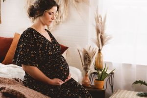 Studio maternity session with flowing fabric and warm lighting by Urso Photography.