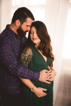Cozy studio maternity photo with Urso Photography, capturing quiet joy before baby arrives.