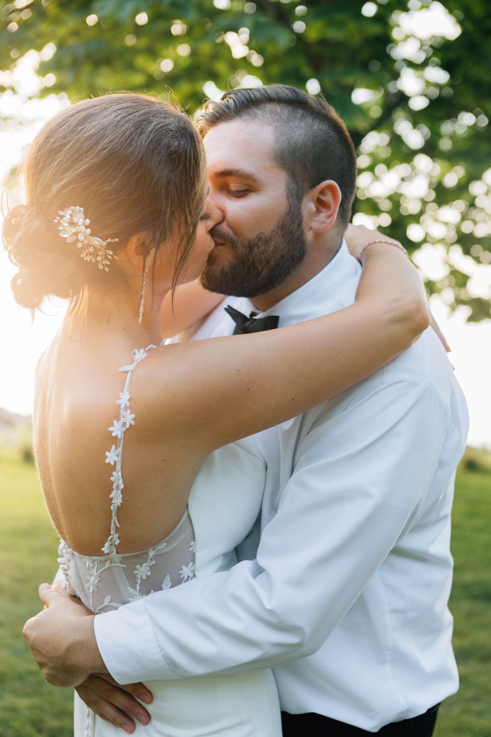 A sunset wedding photoshoot with couple embracing in a natural outdoor setting.