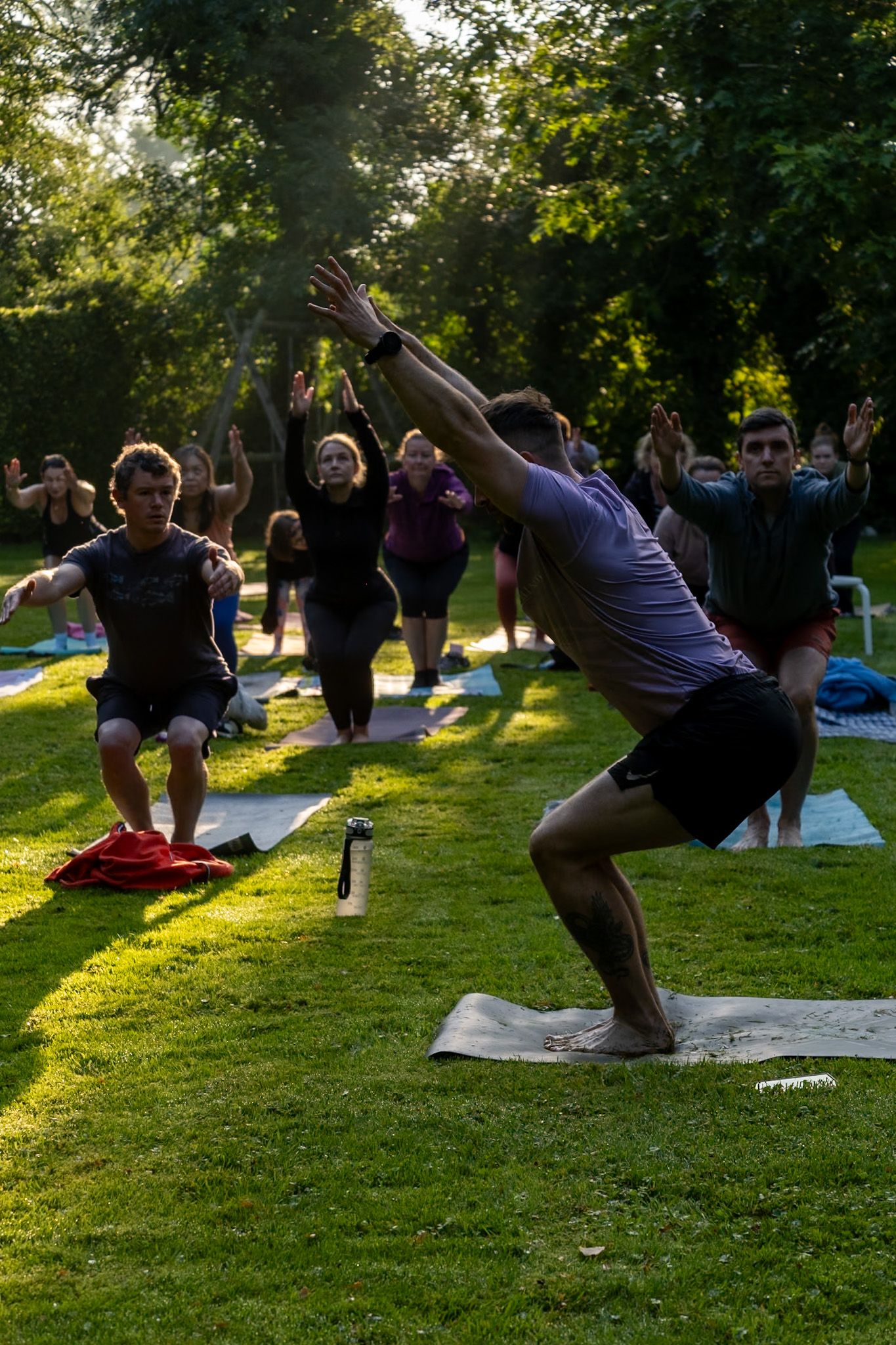 Outdoor yoga class in a sunlit park with participants stretching on mats.
Kildare, Ireland.