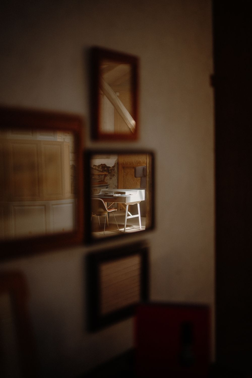 Collection of vintage-style framed photographs arranged on a dimly lit wall.