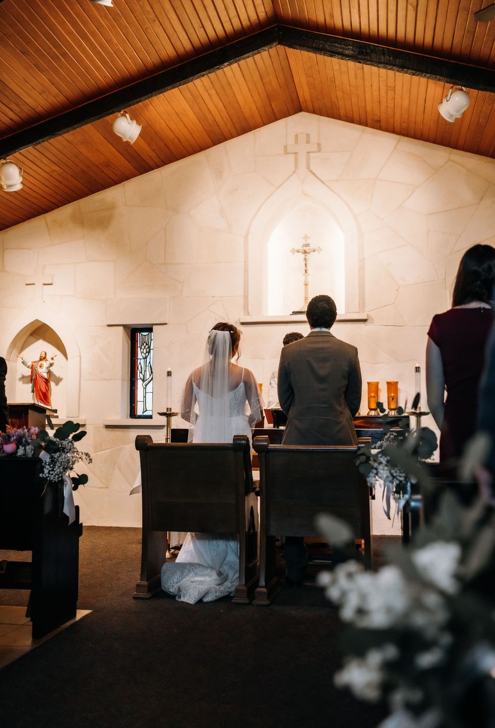 Interior view of chapel during wedding ceremony with wooden ceiling and altar.