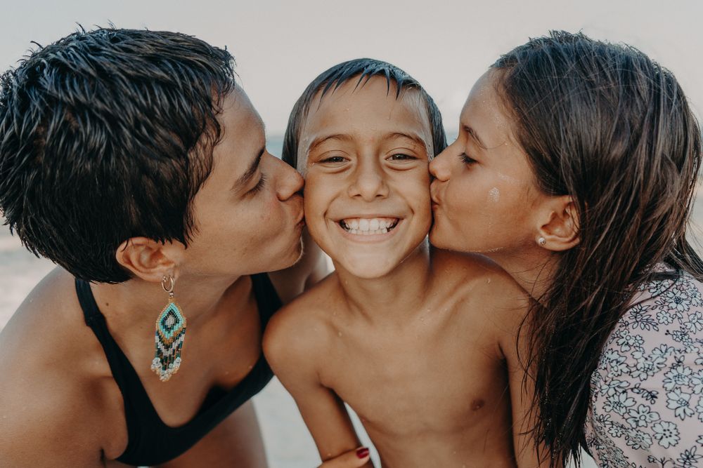 Close up of friends sharing happy kisses and laughter photoshoot in Puerto Morelos.