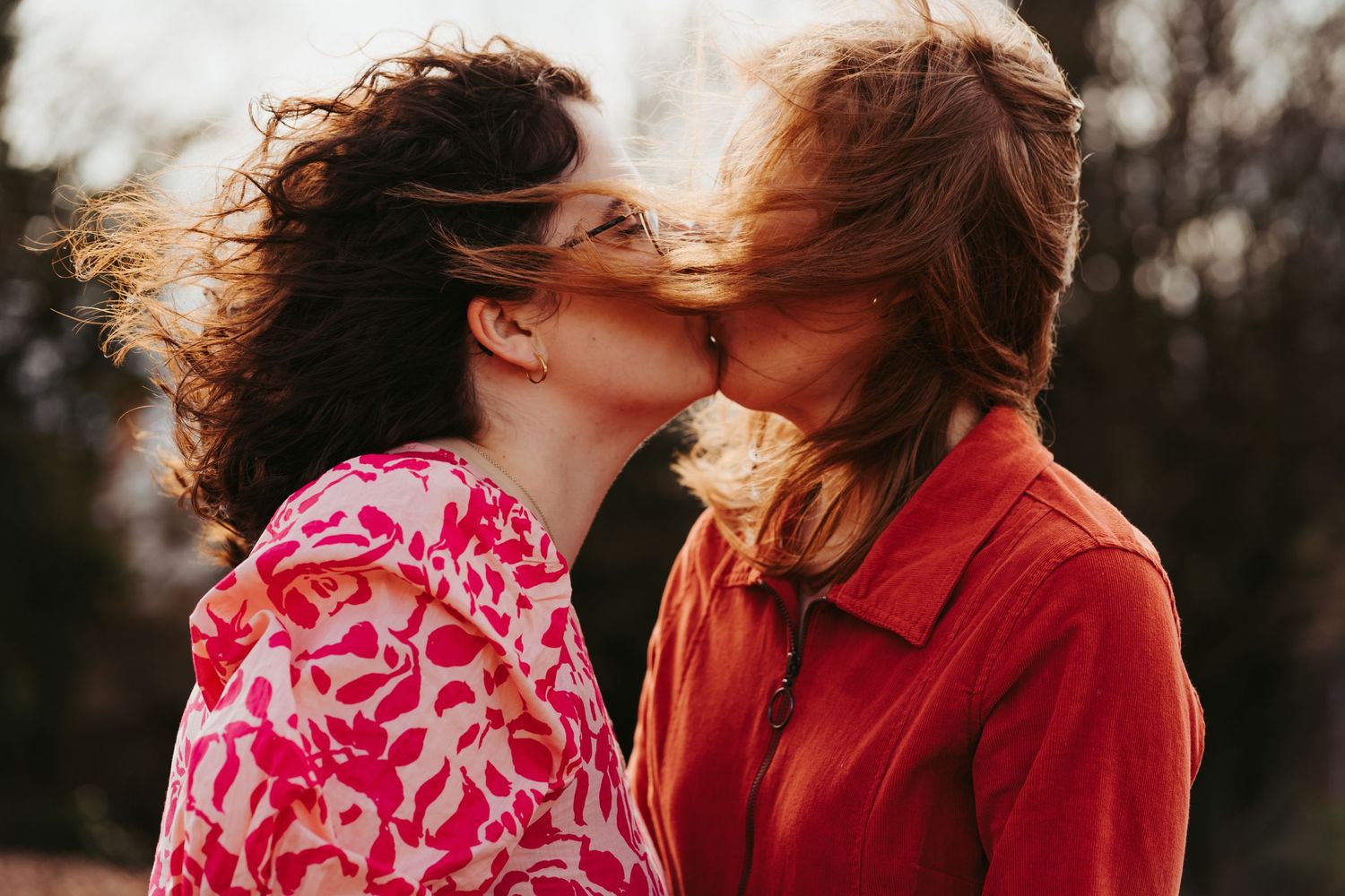 Two brides kiss after intimate Chesterfield ceremony wearing bright pink and orange colours. LGBTQ lesbian Lucy and yaks and doc martens