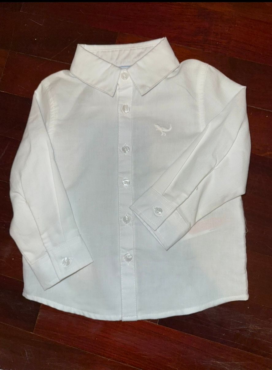 White long-sleeve dress shirt with button front closure laid flat.