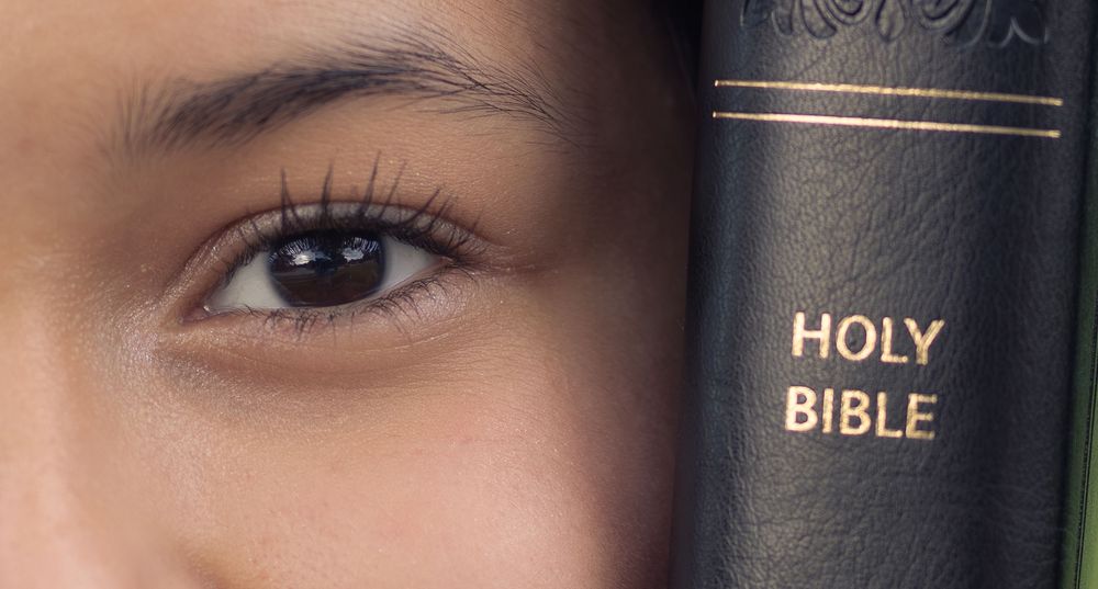Close-up view of black leather-bound Bibles arranged in a row on a shelf. In Pearland, TX