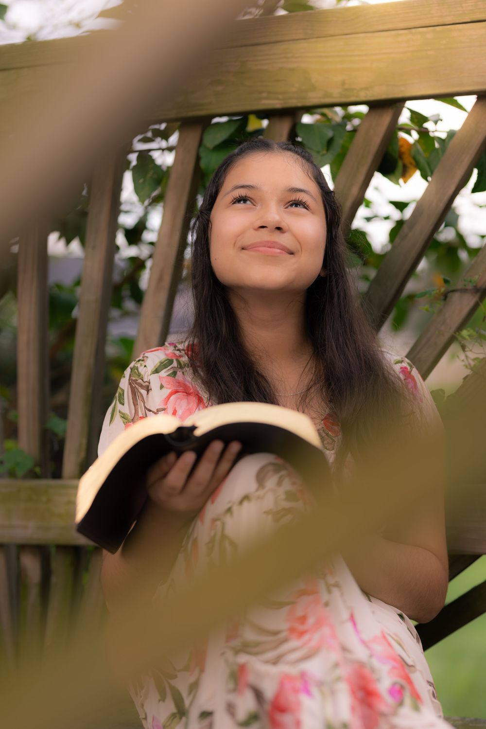 A series of photos show someone looking up while surrounded by green foliage and natural light. In Pearland, TX