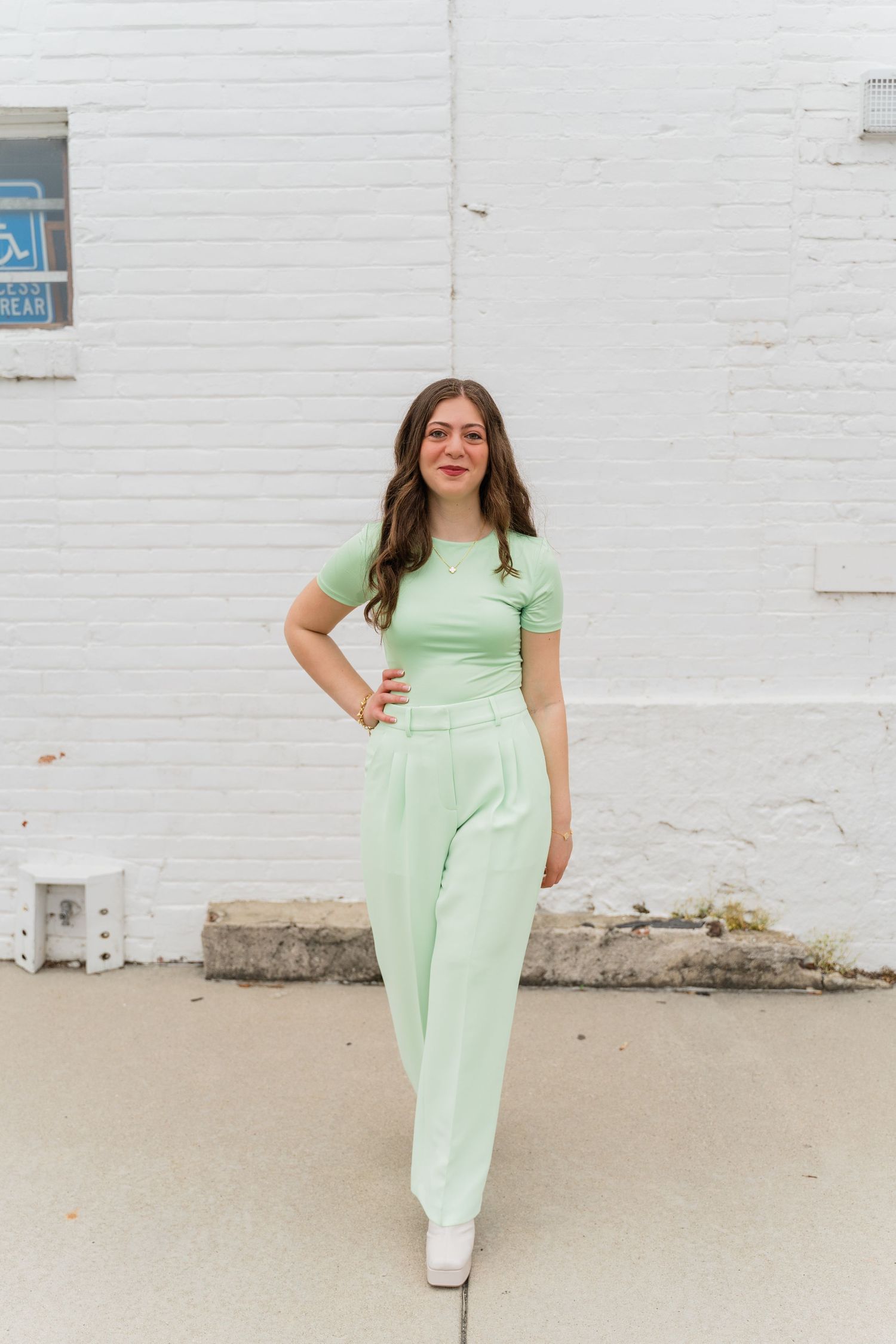 Perrysburg High School senior posing against whitewashed wall for senior photos