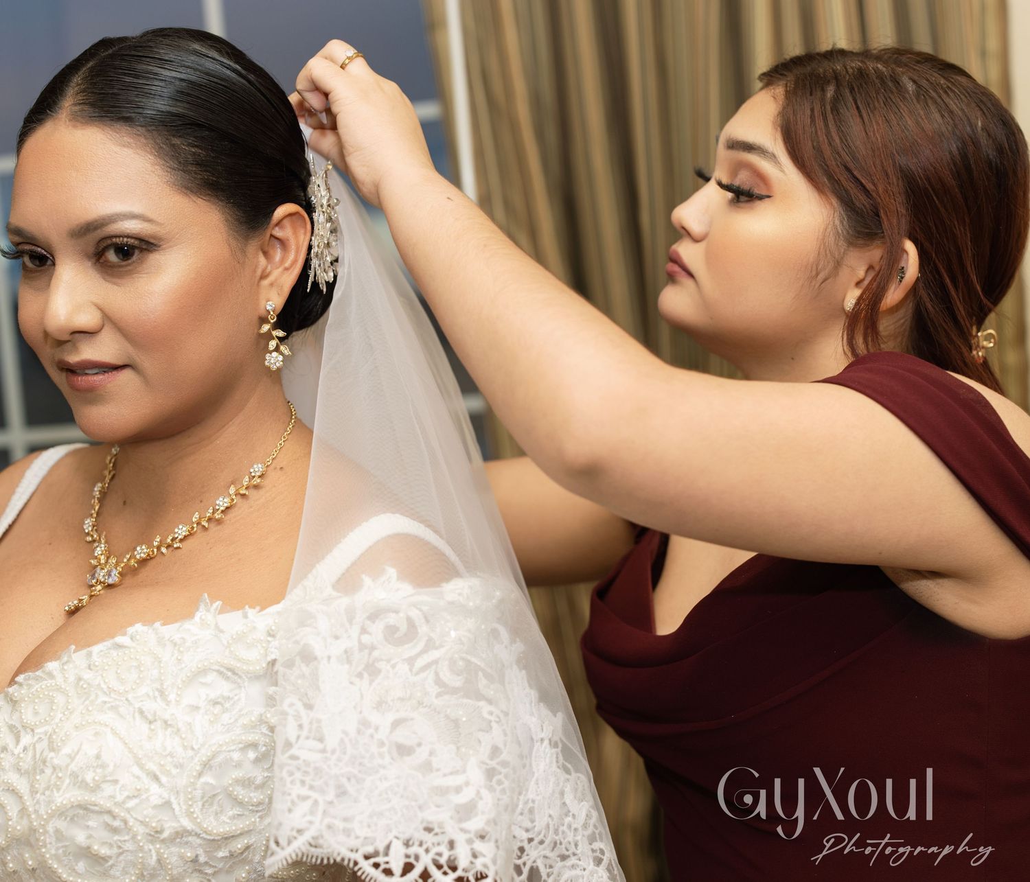 Wedding preparation scene with veil being adjusted.