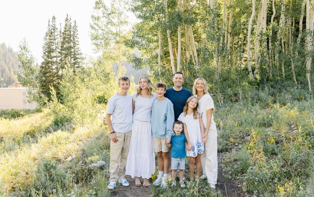 Group portrait in mountain setting with aspen trees and natural lighting.