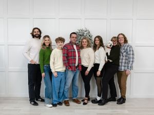 Group portrait against white wall wearing casual winter clothing.