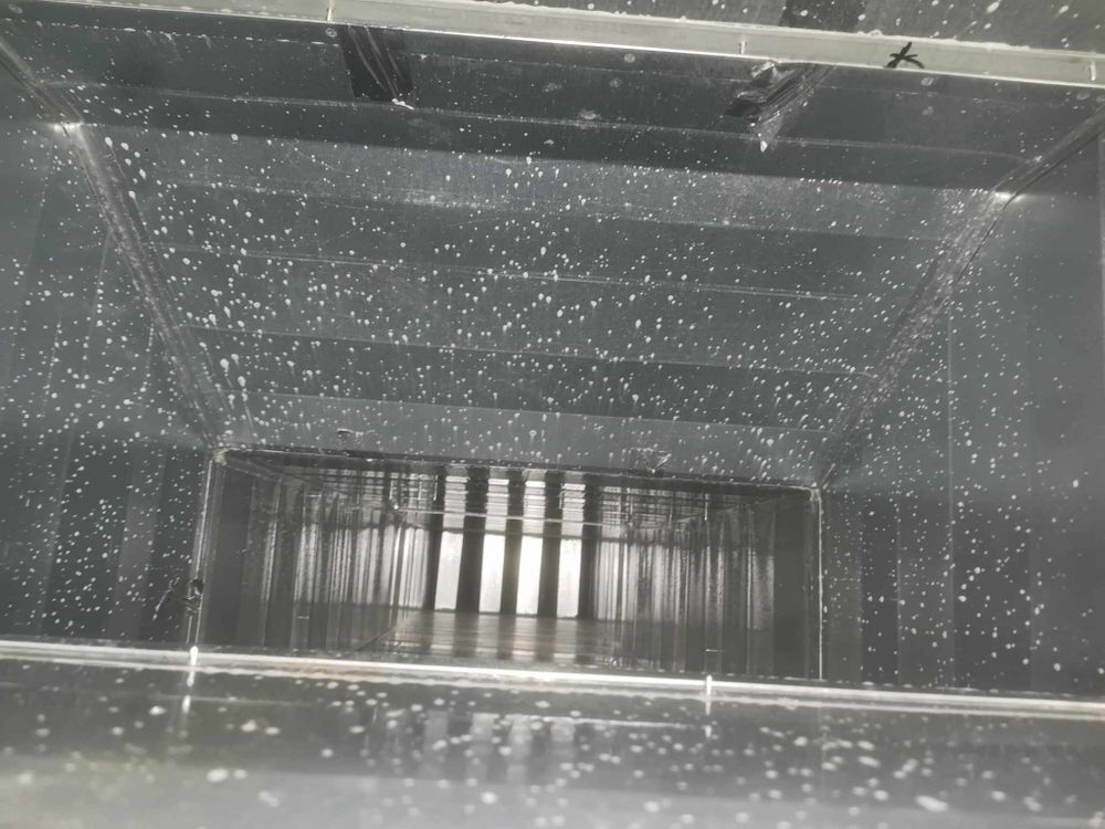 Interior view of ventilation system showing water droplets and metal components.