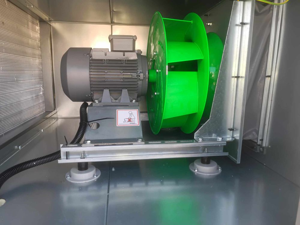 Green-lit industrial equipment and motors mounted inside a mechanical system.