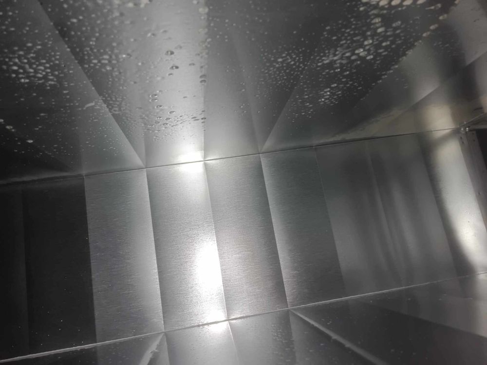Industrial ventilation system interior showing metal ductwork with reflective surfaces.