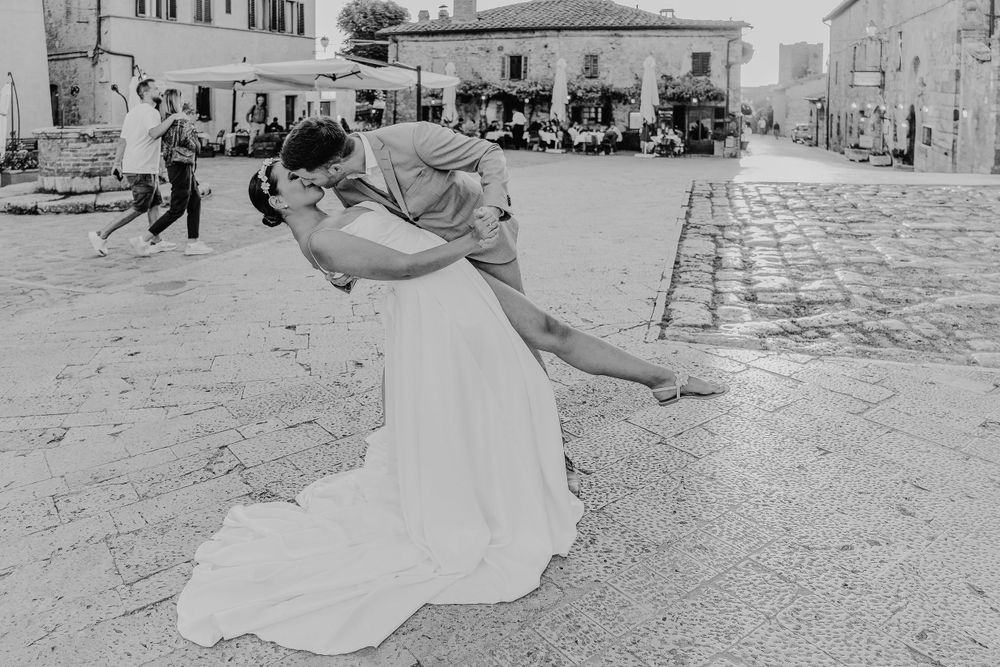 Eine romantische Dip-Pose, die in Schwarz und Weiß auf Kopfsteinpflasterstraßen festgehalten wurde. Monteriggiano Toskana Italien