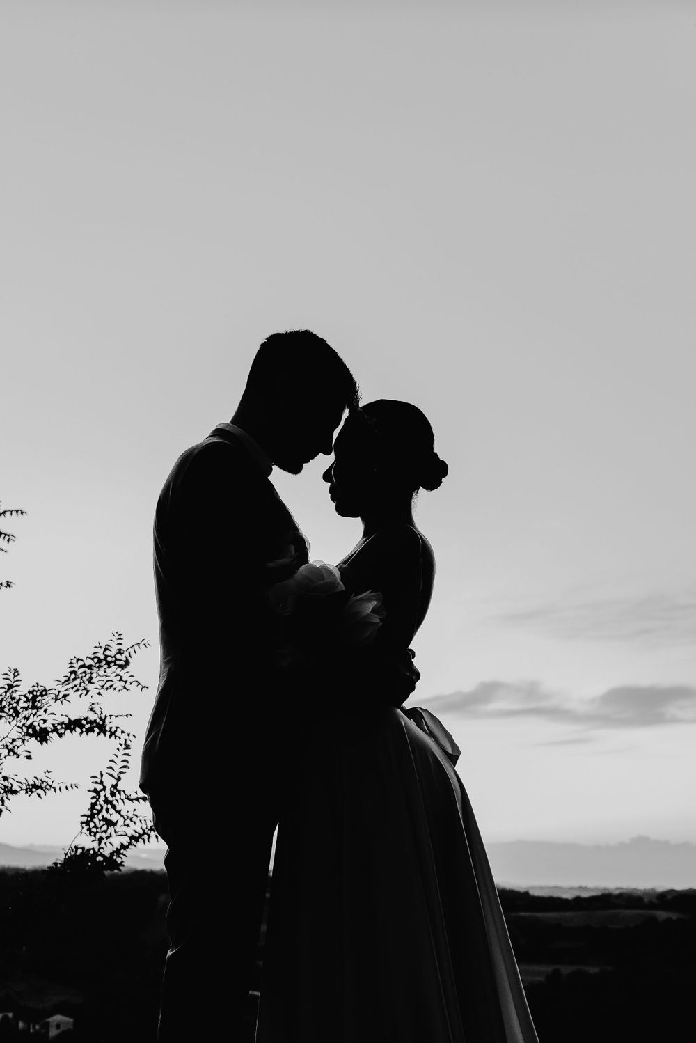 Ein Paar mit Silhouetten teilt einen intimen Moment vor dem Sonnenuntergangshimmel. Monteriggiano Toskana Italien