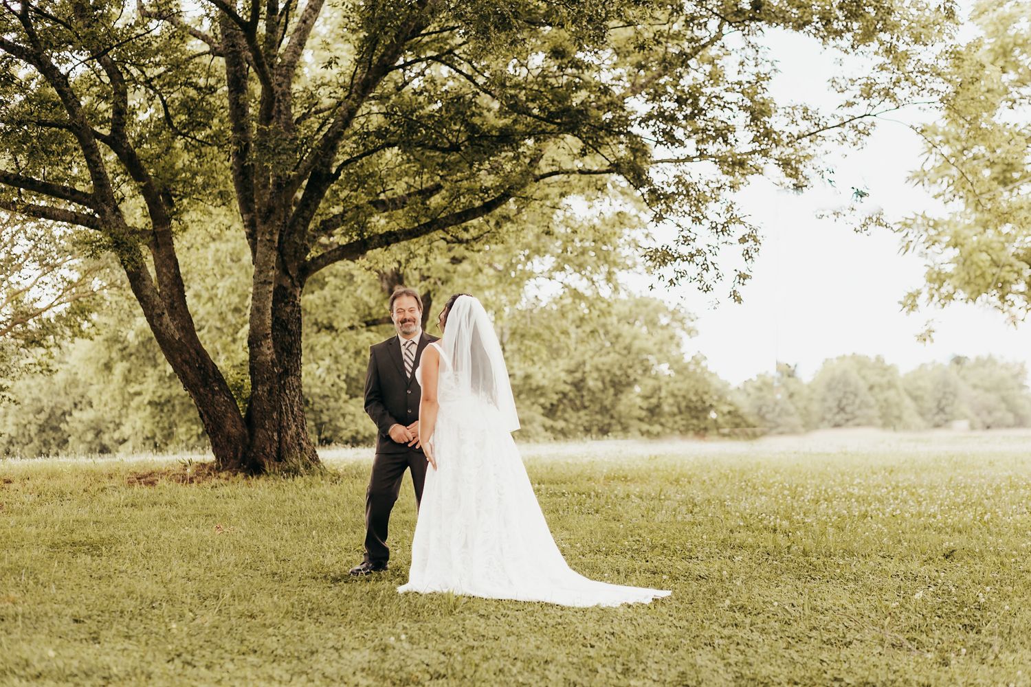 bride walking up to surpise her dad in her wedding gown