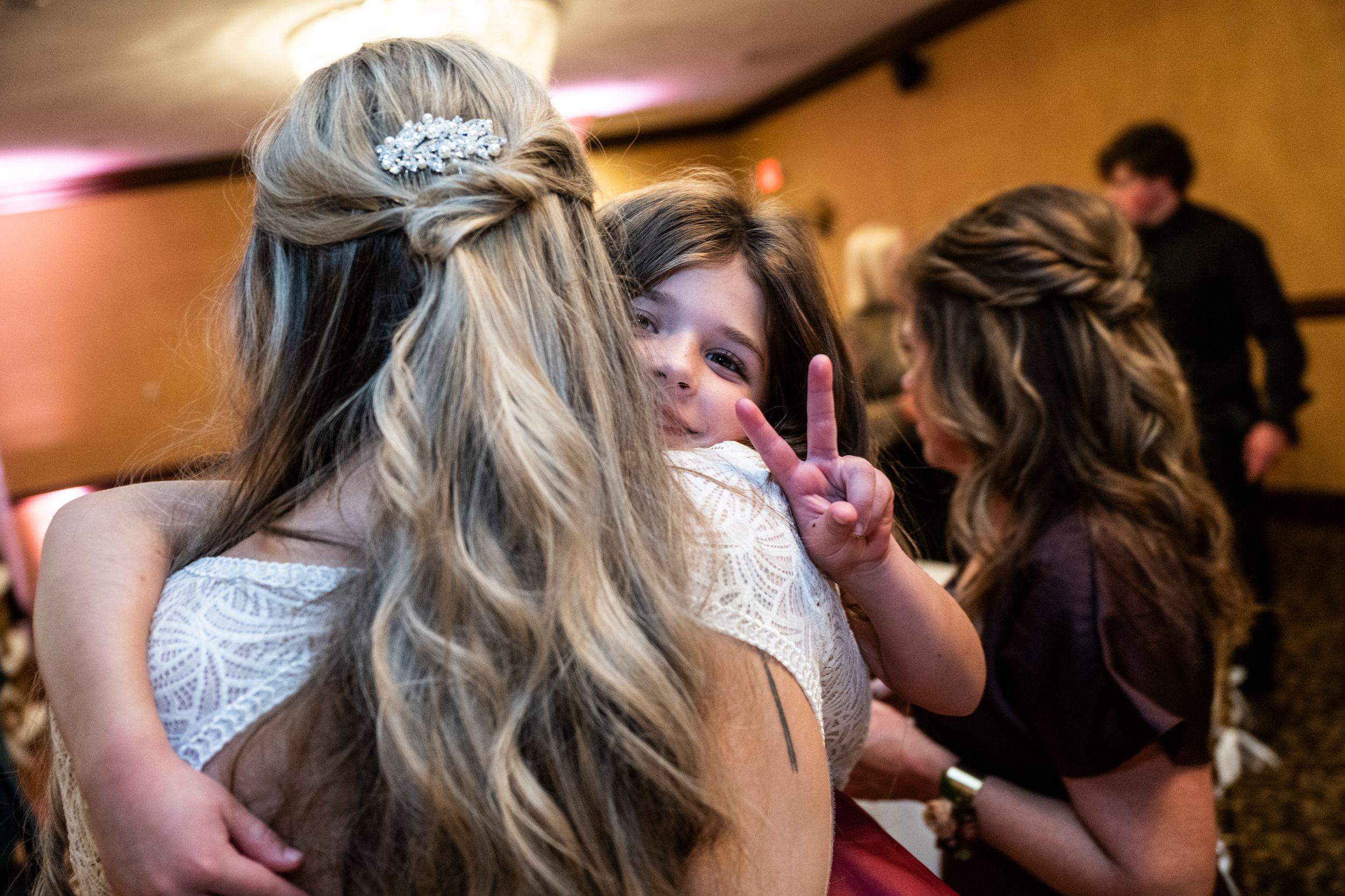 People dancing together in close embrace on a carpeted dance floor at an indoor celebration venue.