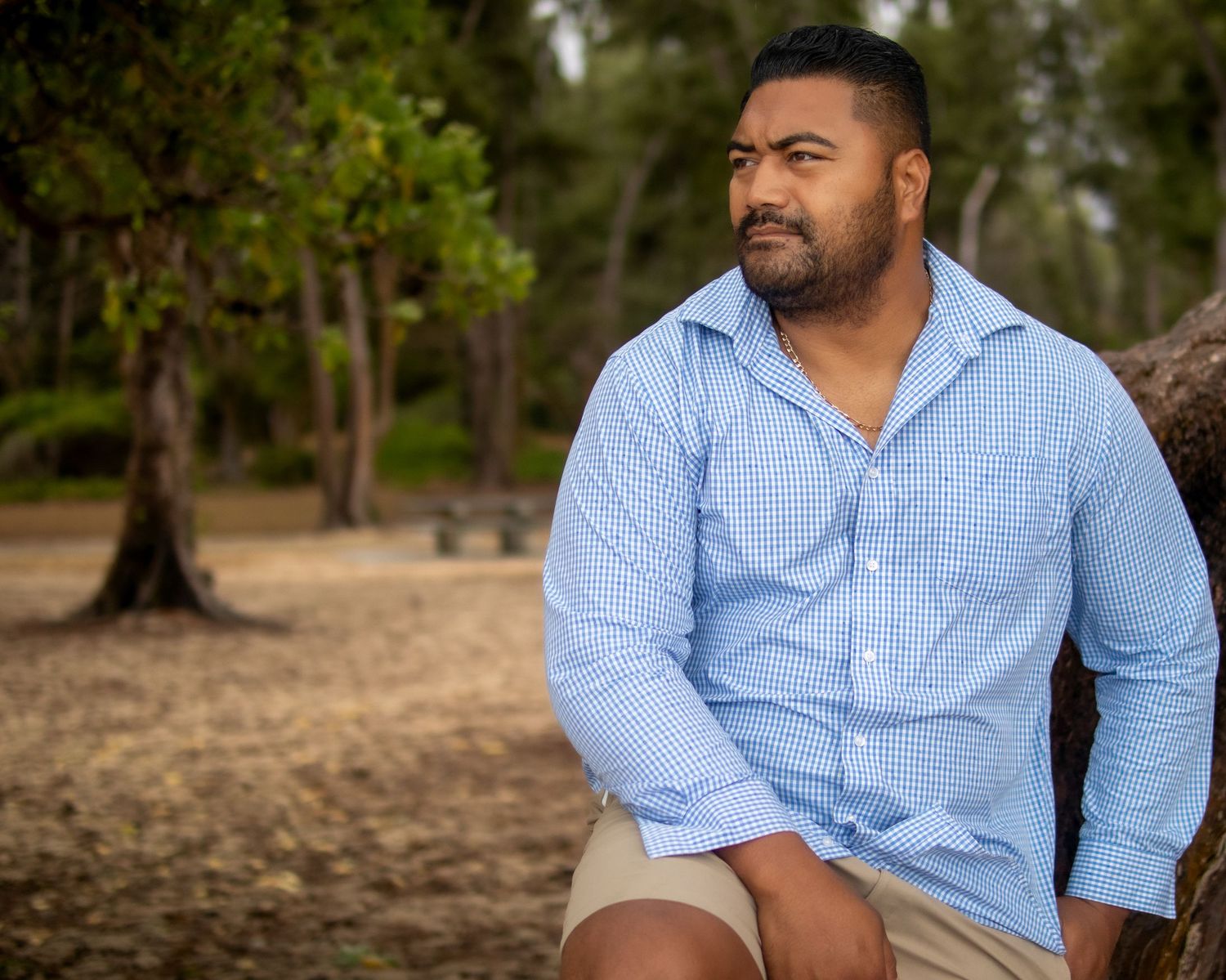 Man standing stoically, gazing at the ocean — moody Hawaii beach portrait by Live Tribe Media.