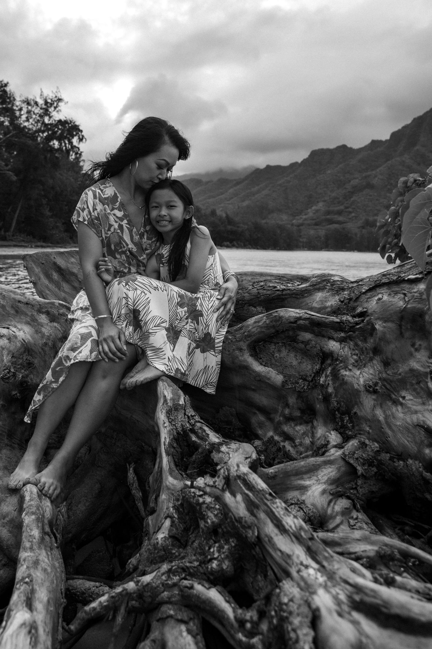 Mom and daughter holding each other at sunset on the beach — heartfelt Hawaii family photo by Live Tribe Media.