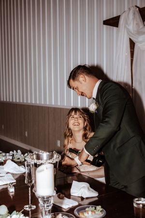 Wedding guests enjoying a formal dinner reception at tables decorated with floral centerpieces.