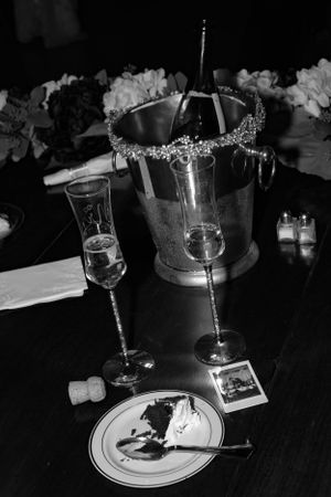 Black and white photo of elegant table settings with wine glasses and place settings.