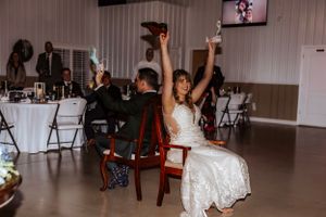 Wedding reception venue with white walls and folding chairs set up for celebration.