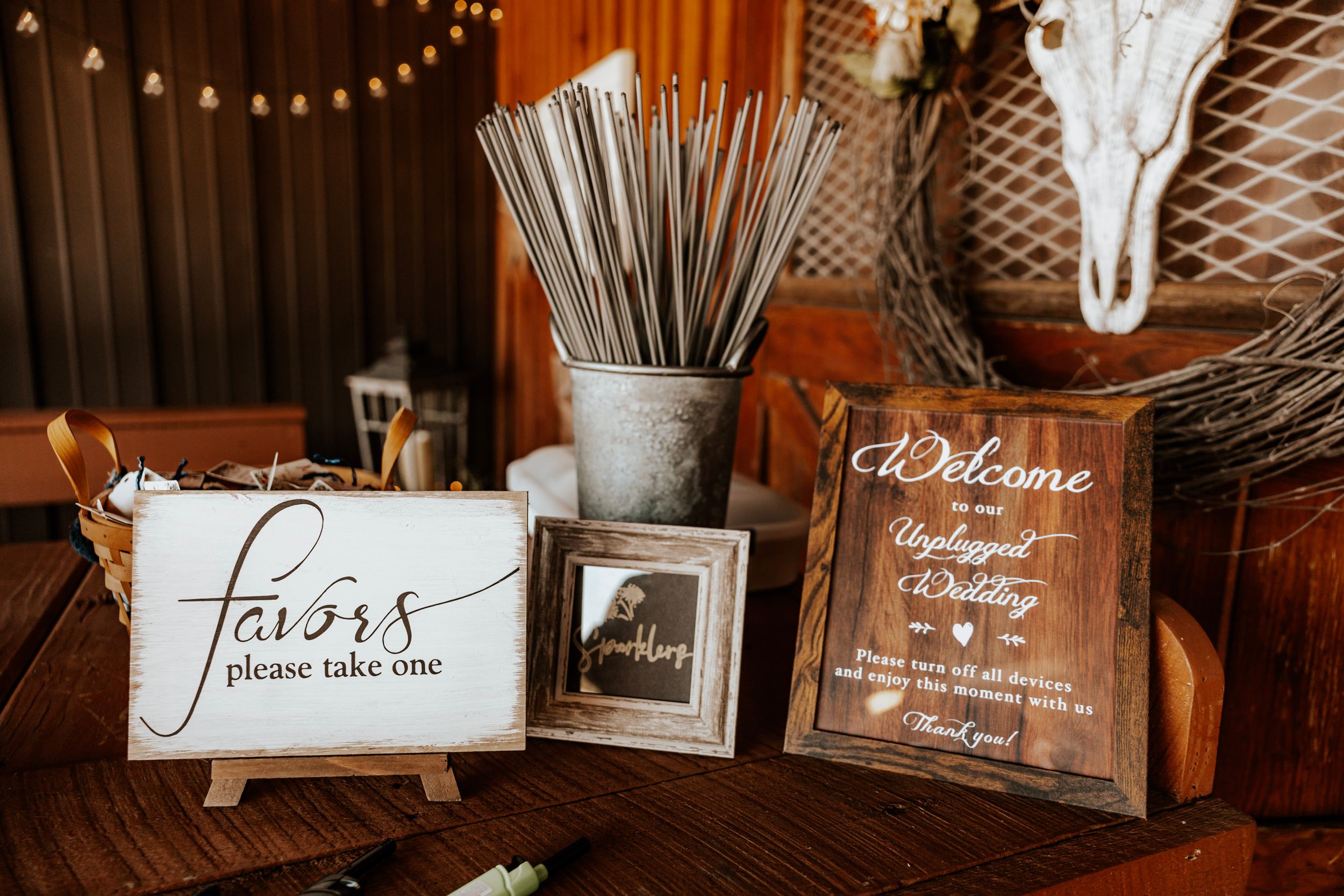 Rustic wedding reception decor with string lights and wooden signs creating warm ambiance.