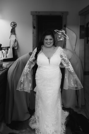 Close-up of white lace wedding dress details in black and white photography.