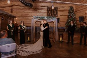 Rustic wooden barn venue decorated for wedding reception with string lights.