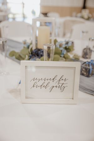 Elegant wedding reception table settings with calligraphy name cards and minimalist decor.