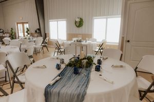 Clean white wedding venue interior with folding chairs and natural light.
