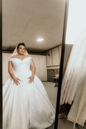 Wedding dress fitting session showing the full volume of an elegant white ballgown style dress.