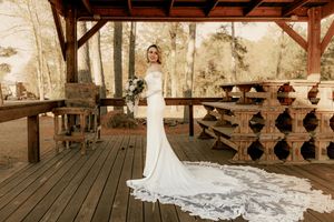 Elegant wedding reception setup under wooden pavilion with hanging decorations.