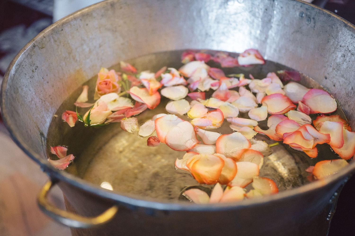 Sliced almonds and shrimp cooking in a silver frying pan with oil.