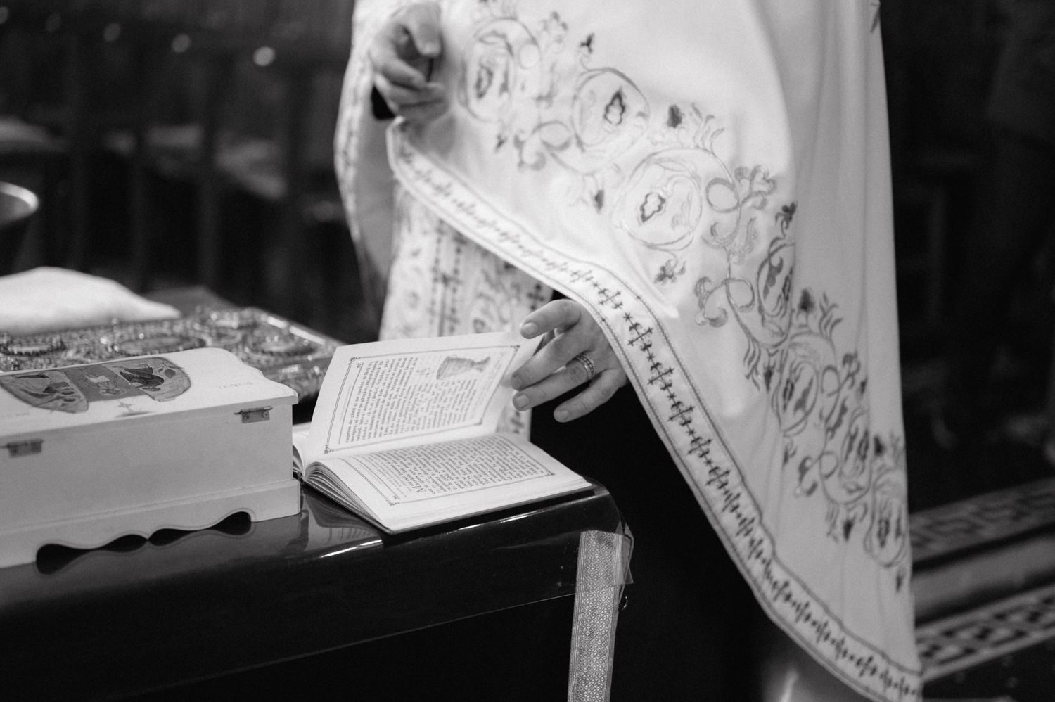Black and white photograph of handwritten sheet music and an open book resting on a piano.