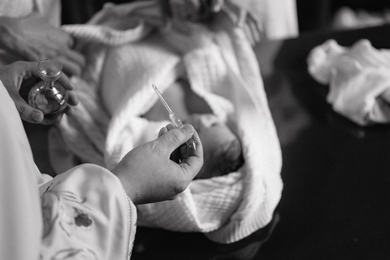 A black and white close-up photograph of a crying baby's mouth showing tiny teeth breaking through the gums.