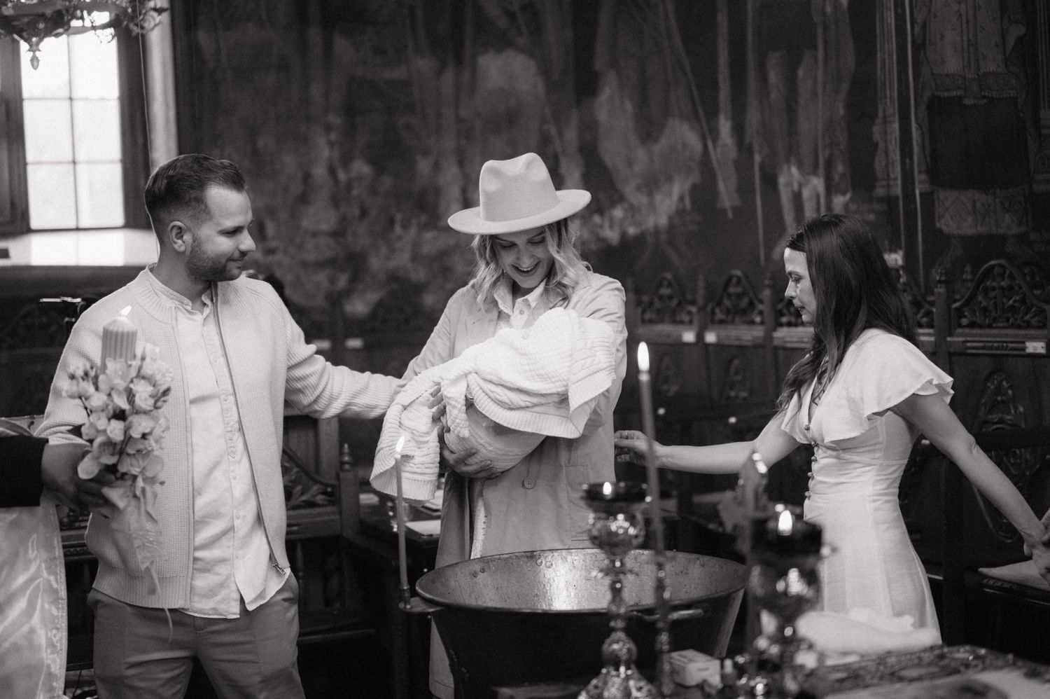 A group of people sharing a candid moment together while holding beverages in a rustic indoor setting.