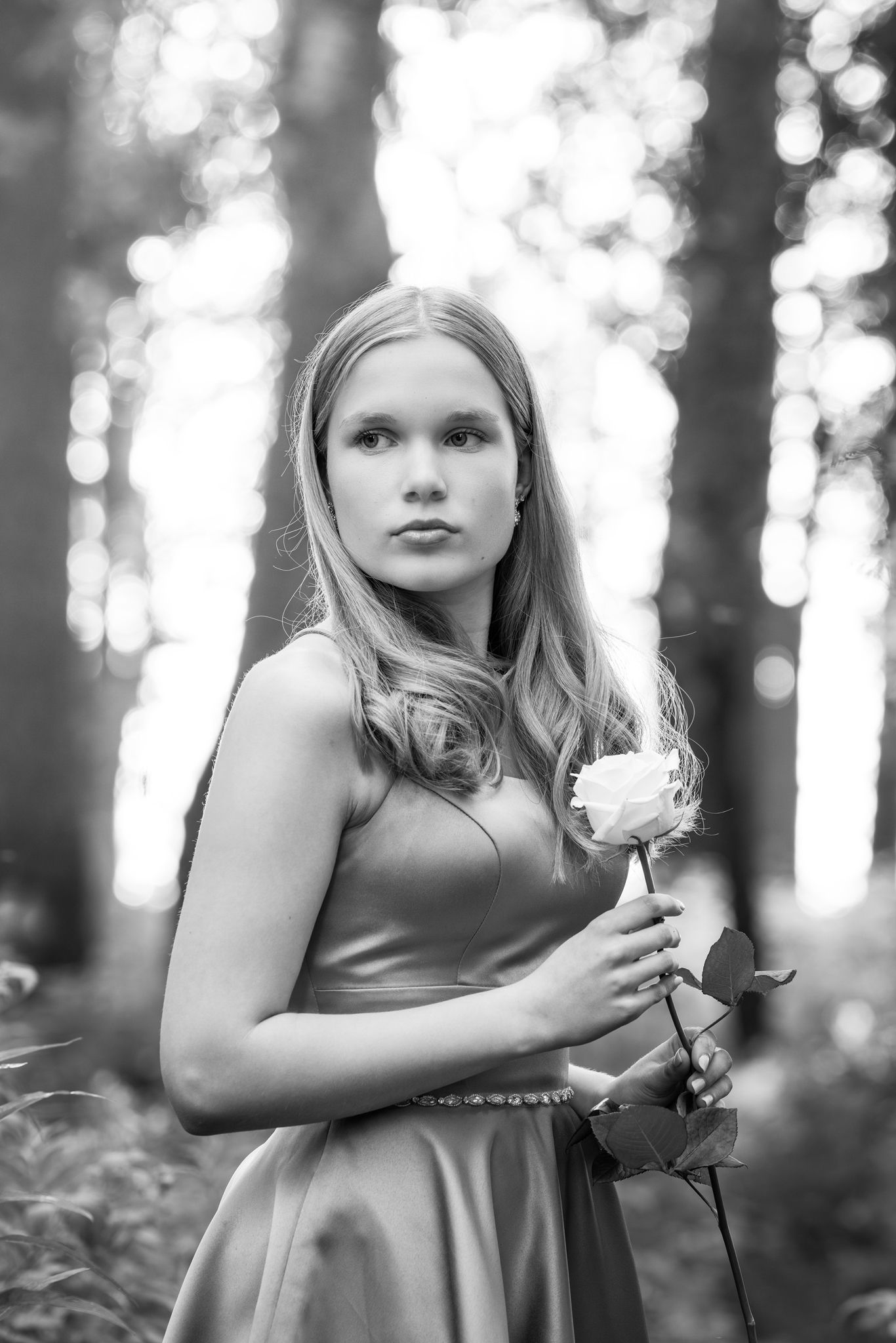 A series of black and white artistic portraits capturing a dreamy forest scene with soft bokeh lighting effects.