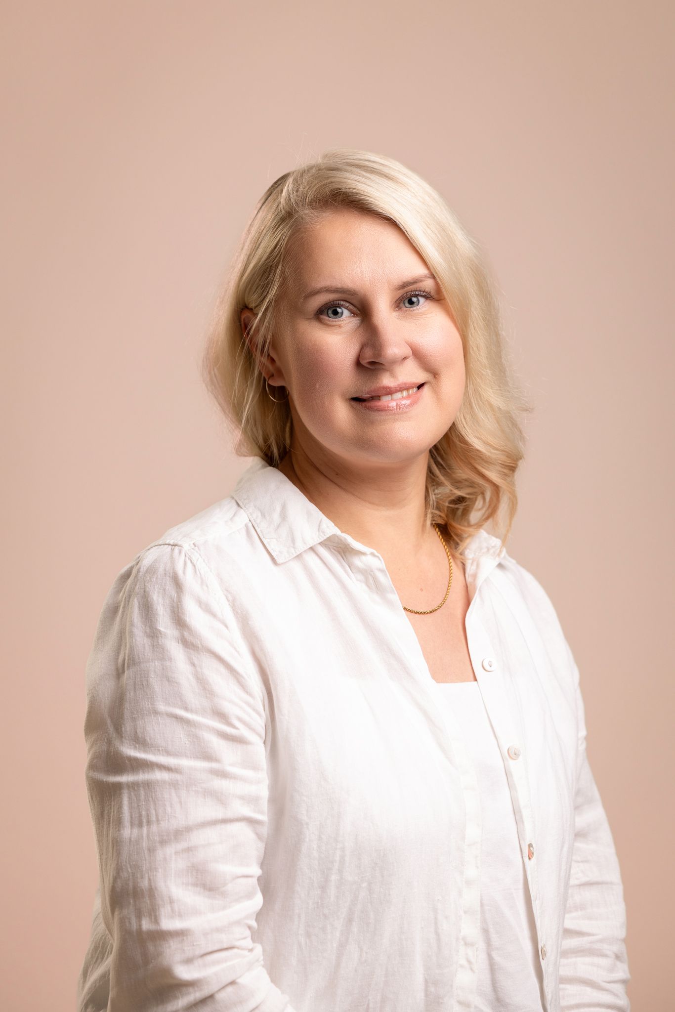 Valkoiseen puseroon pukeutunut nainen potrettikuvassa