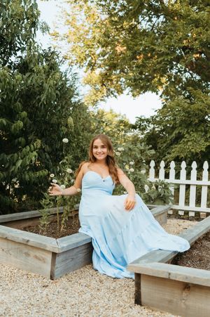 A series of photos showing someone in a patterned dress posing thoughtfully against a waterfront background.