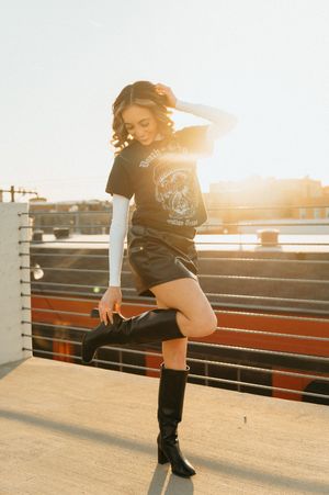 A sequence of sunset photos showing someone posing on bleachers in casual wear and tall boots.
