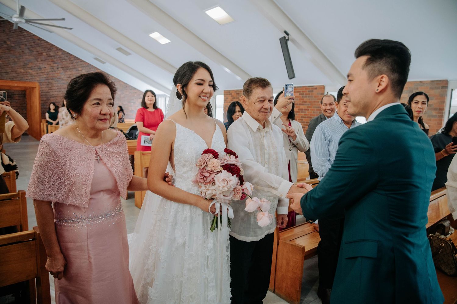 Happy wedding ceremony takes place inside a church with brick walls as guests celebrate the joyous moment.