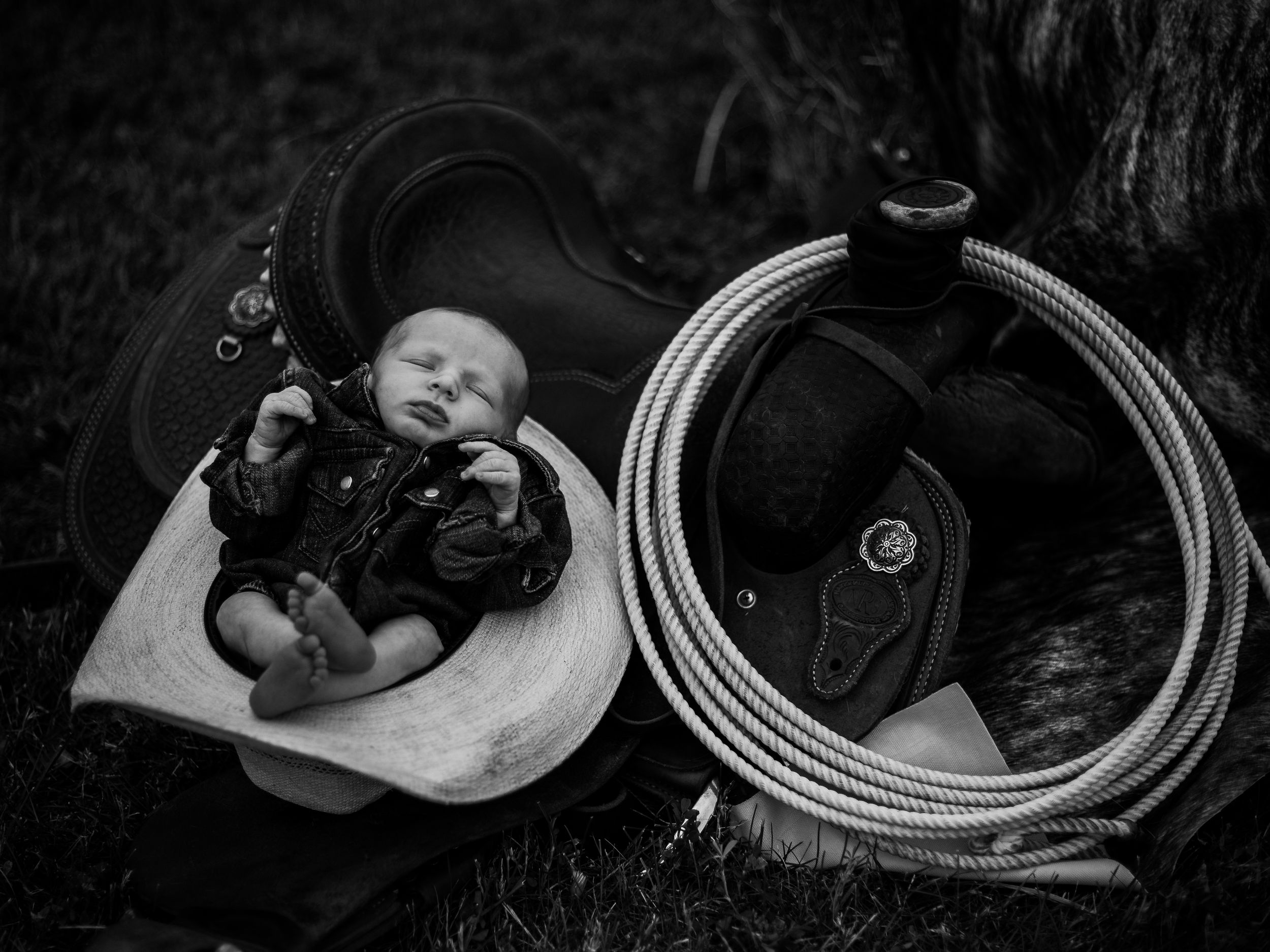 Black and white photo series showing a baby sleeping in various positions on a soft surface.
